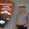 Mike Whatley posing with a National Park Service sign